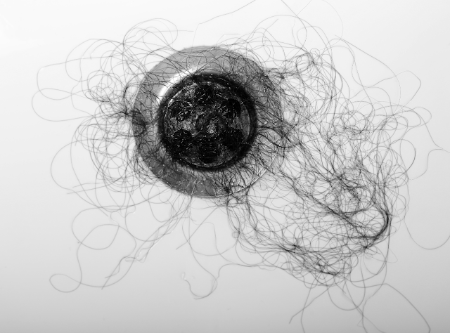 Image of clump of hair on shower drain.