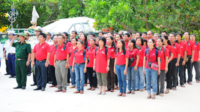 Thành viên chuyến tàu “Góp đá xây Trường Sa” chào cờ ở đảo Sơn Ca - Ảnh: T.T.D.