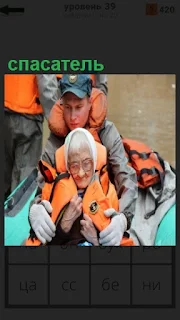 в лодке спасатель везет пожилую женщину в спасательном жилете