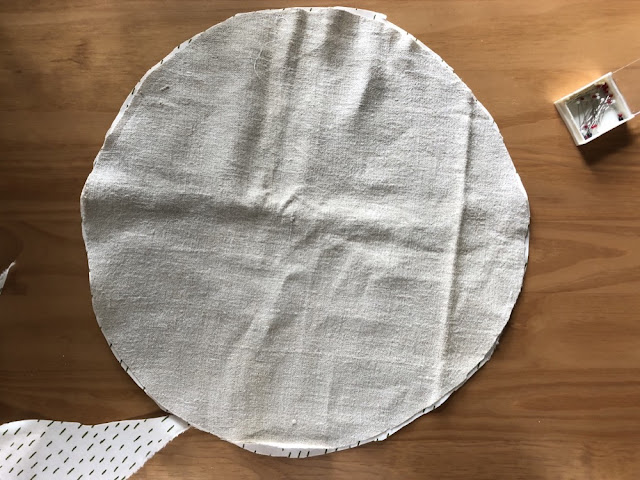 Two circles of fabric on a wooden table top.