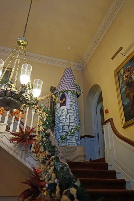 Rapunzel's Tower with her golden hair let down, as it goes down the banister of the stairs with floral decorations