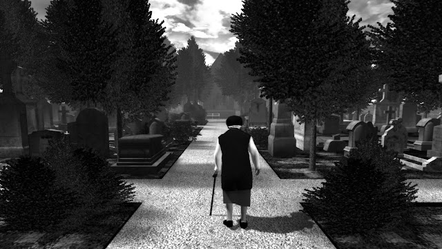 Kuvakaappaus pelistä The Graveyeard. Mustavalkoinen kuva, jossa vanha nainen kävelee hautausmaan käytävää pitkin kävelykeppiin nojaten. Edessä näkyy kirkko ja valkoinen puistonpenkki.