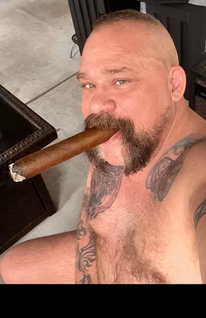 Horseshoe bearded bear with a hairy chest shirtless tattooed cigar and mouth smiling