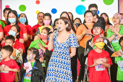 Singer Karylle leads the CHILD Haus children in an uplifting song.