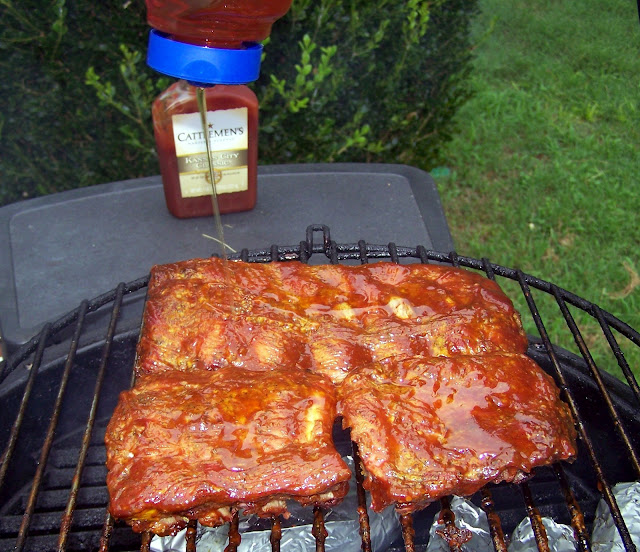 Squeezing honey on top of two slabs of ribs