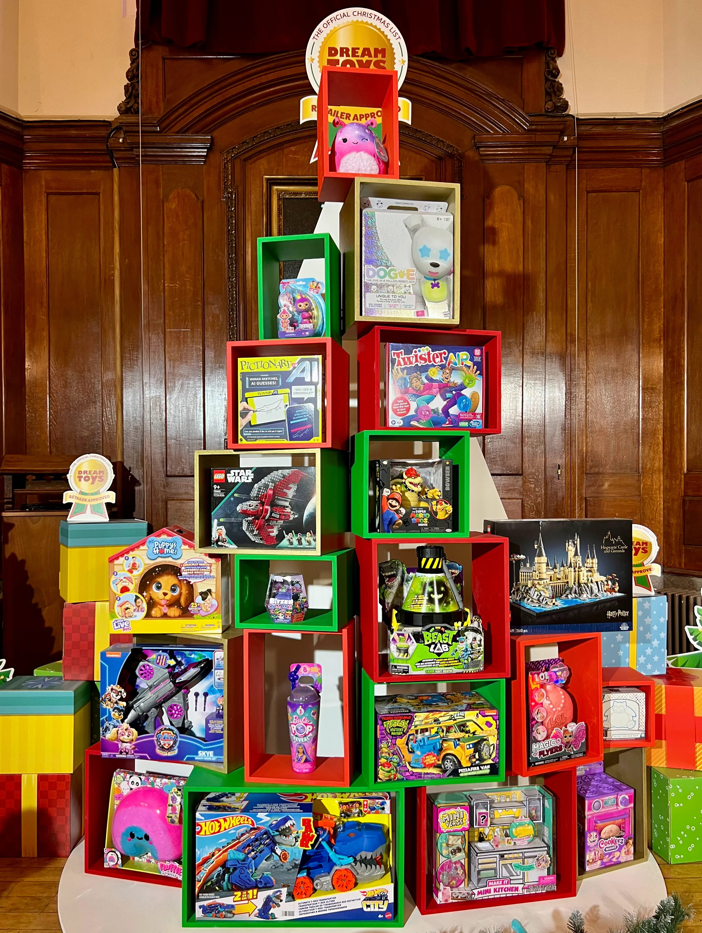 A christmas tree shaped stack of shelves with the toy retailers DreamToys for this Christmas