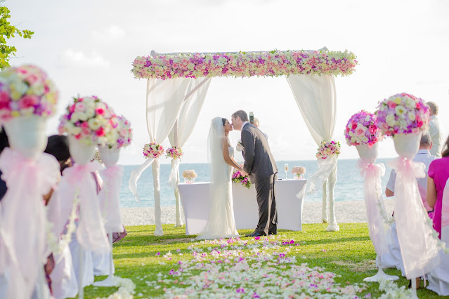 A bride and groom kissing at their beach Wedding
