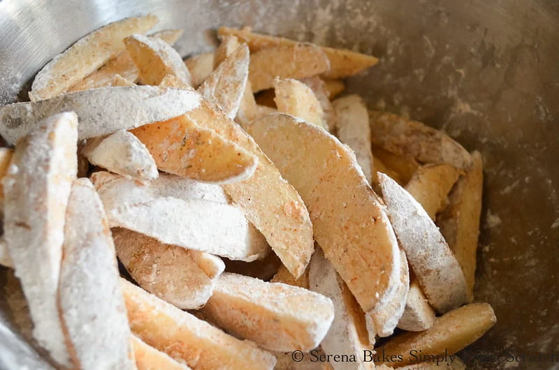 Seasoned Jo Jo Fries resting in seasoned flour mixture.