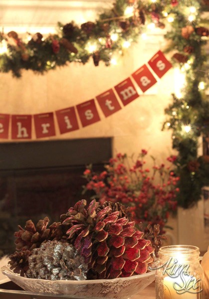 Glittered pinecones in front of christmas mantel