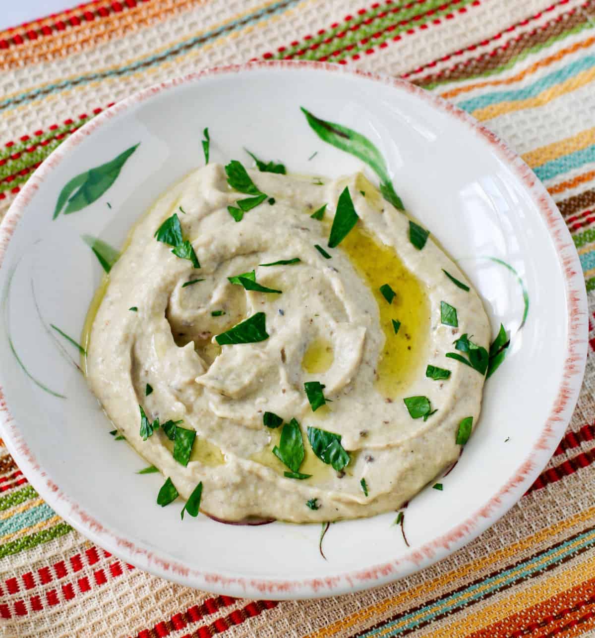 Baba Ghanoush (Roasted Eggplant Dip) in a small bowl with parsley on top.