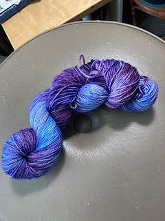 a skein of yarn shading from a deep purple to a vivid cobalt blue