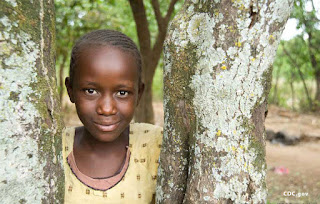 A girl leans against a tree in the village of Usoma — CDC photo