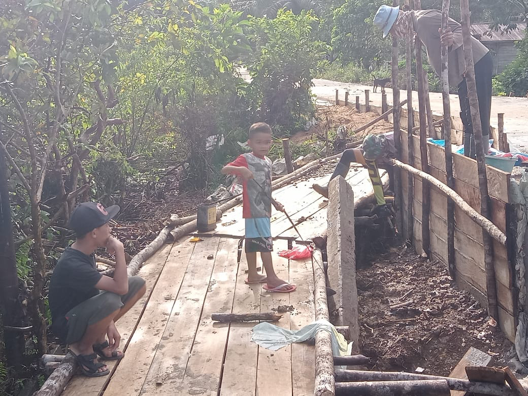 Anak anak desa bermain di jembatan darurat yang di buat anggota satgas TMMD