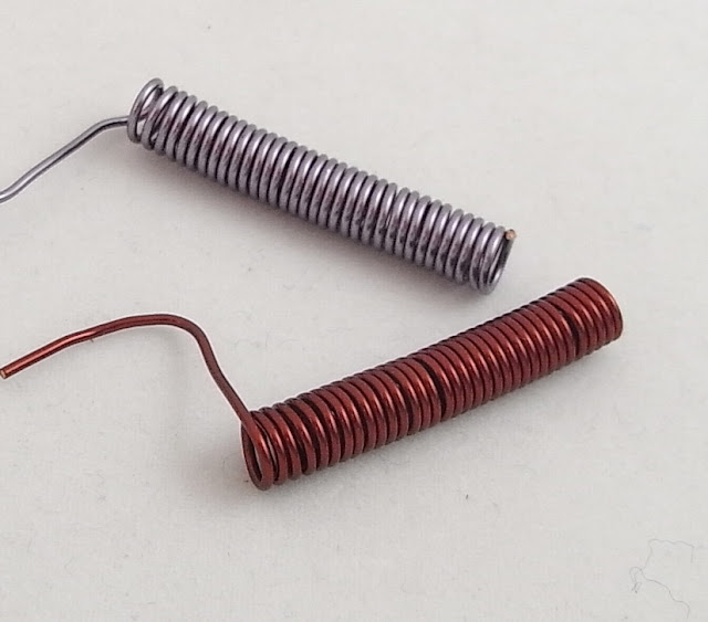 Mauve coil and rust coil of waiting to be cut into jump rings.