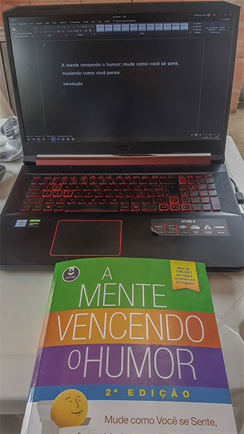 notebook com um livro na frente