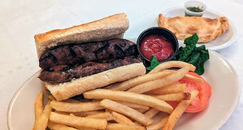 Choripan served with fries and an empanada on the side