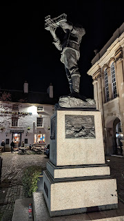 Statue of Charles Rolls at night, light from below, Monmouth