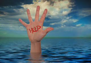 A drowning man's hand is raised above the water, with the word "help" painted on it.