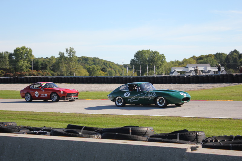 Coming out of turn 14 a ’64 Jaguar XKE pulls away from the ’72 Datsun 240Z