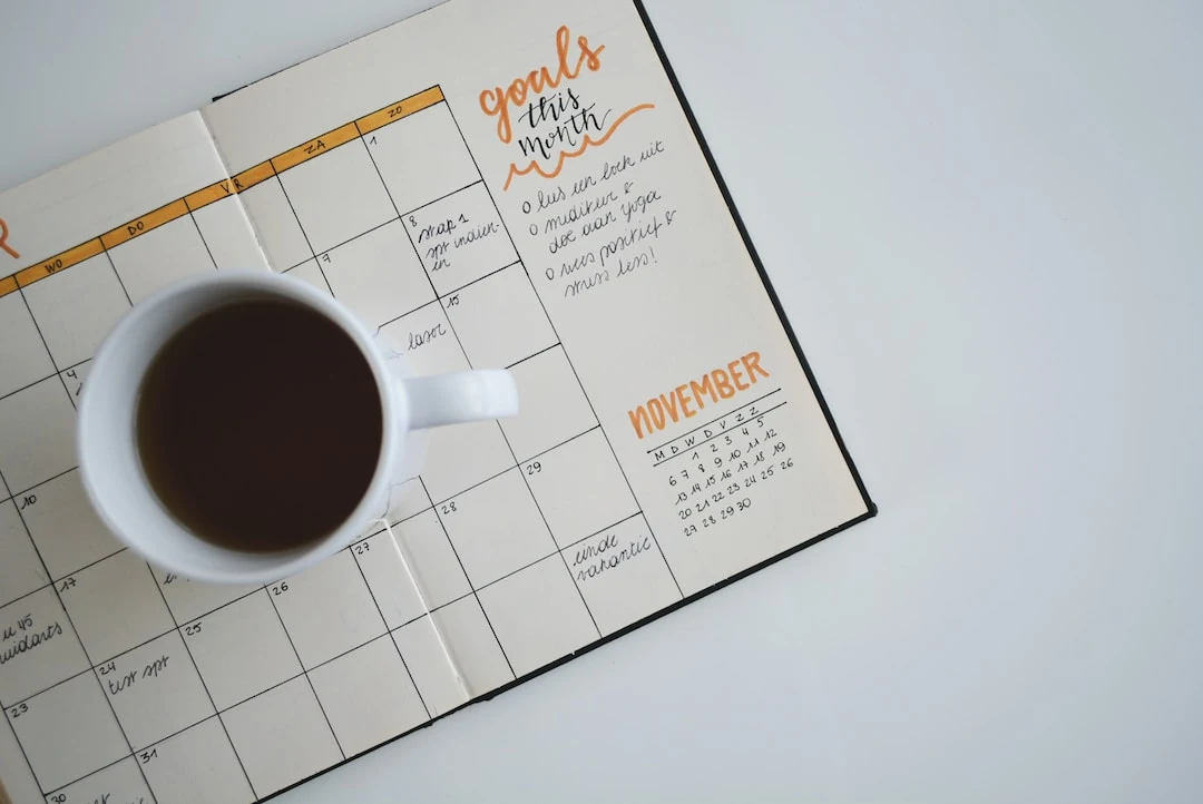 Coffee cup on the planner book on the desk photo