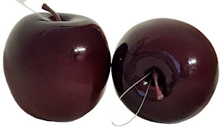Ein Apfel aus Kunststoff in der Farbe Bordeaux, hochglänzend
