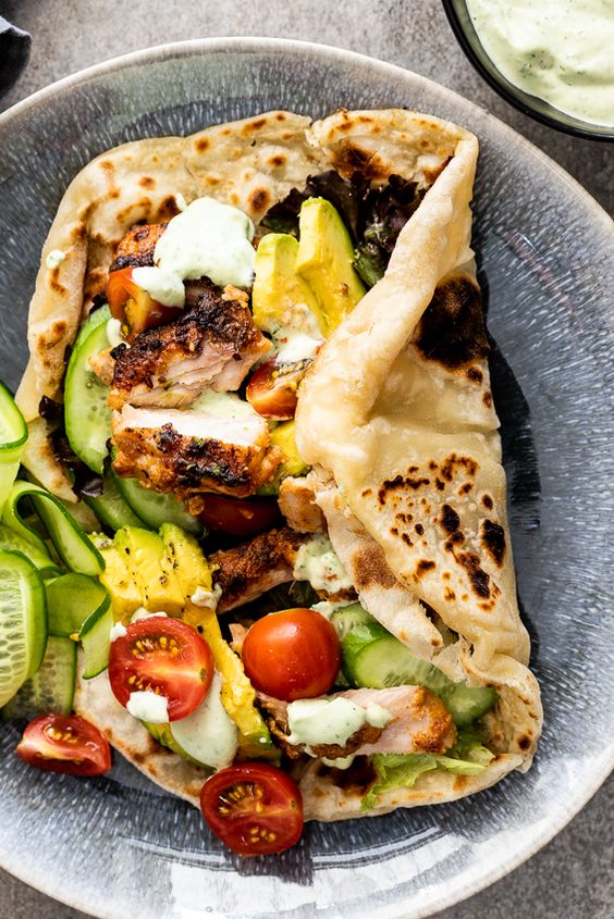 Juicy chicken shawarma marinated in spiced yogurt then grilled is a delicious dinner served wrapped in easy flatbread with crunchy vegetables.