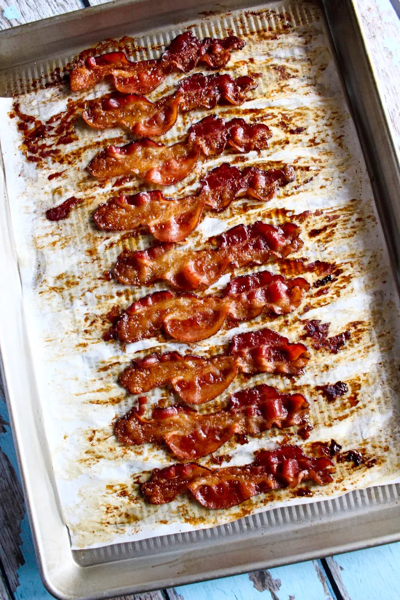 Oven fried bacon on a baking sheet lined with parchment paper.