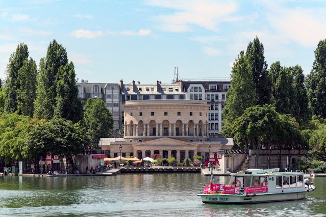 boat on the water in front of the Rotonde de la Villette in Paris