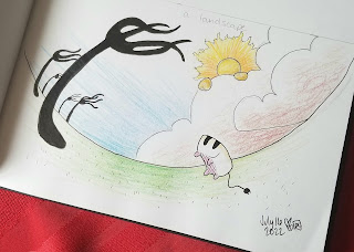 A photograph of a pen and colored pencil drawing in a sketchbook on red fabric. The drawing is of a fantasy landscape, with black forks for trees, a lion in the clouds for a sun, and a single white toaster jumping in the air.
