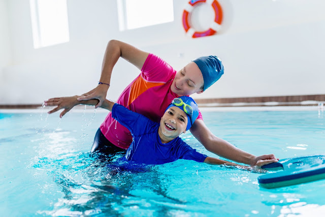 mns apprend à nager à un enfant dans piscine