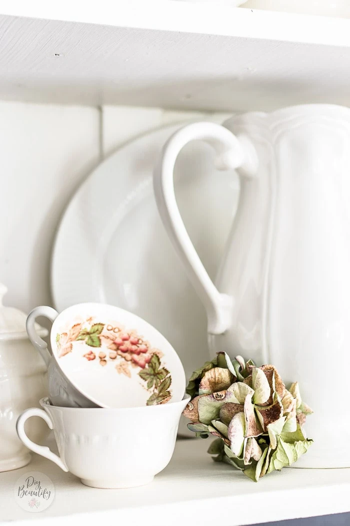 white ironstone pitcher, vintage teacups and dried hydrangea stem