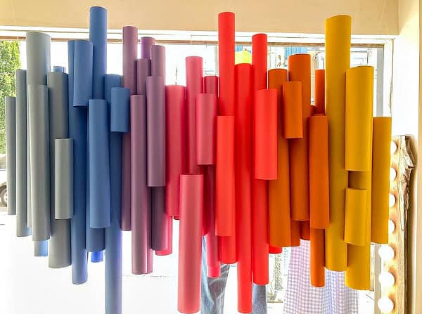 detail of colorful, vertically hung paper tubes as store window display