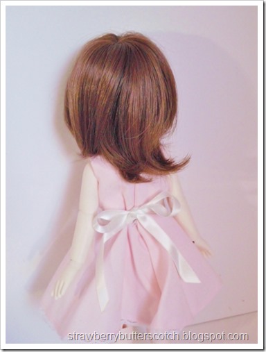 A pink vintage style dress set for a doll.