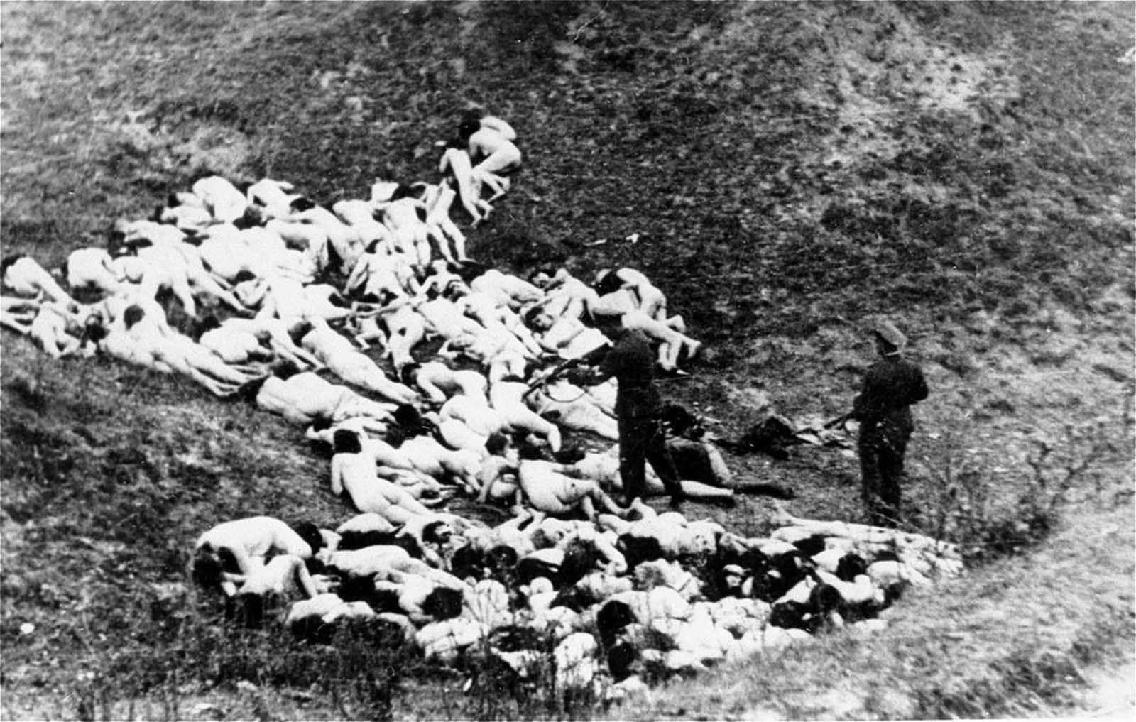 A German in a military uniform shoots at a Jewish woman after a mass execution in Mizocz, Ukraine. In October of 1942, the 1,700 people in the Mizocz ghetto fought with Ukrainian auxiliaries and German policemen who had intended to liquidate the population. About half the residents were able to flee or hide during the confusion before the uprising was finally put down. The captured survivors were taken to a ravine and shot. Photo provided by Paris' Holocaust Memorial.