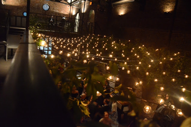 A canopy of String Lights w/ G50 Bulbs suspended in the Main Room at The Foundry in a zigzagging pattern.