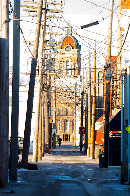 Image by J. Allen Wood; Goshen, Indiana courthouse as seen from an alley with the silhouette of a man in the distance