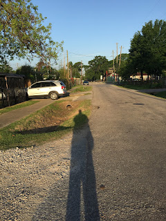 Shadow of myself as I walk to the train on a narrow street in the small square of God's green earth that I call Home and Lindale