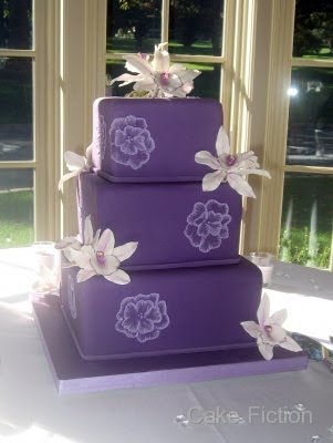 Square three tier white purple and green wedding cake
