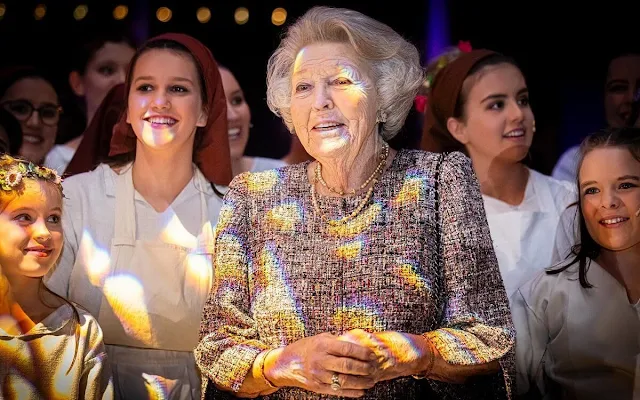 Princess Beatrix wore a multi color tweed jacket, gold necklace and gold earrings. In Vrijheid Verbonden