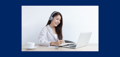 SmilingAsian women wearing headphones having an online lesson on a laptop.