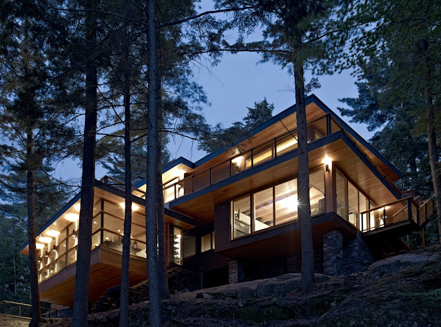 Photo of the forest house built on the hilly terrain at sunset
