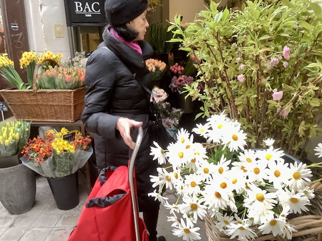 Woman looking at flowers on display in street