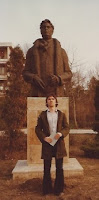 George in front of a statue in the park