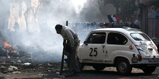 An Egyptian stands near a small car