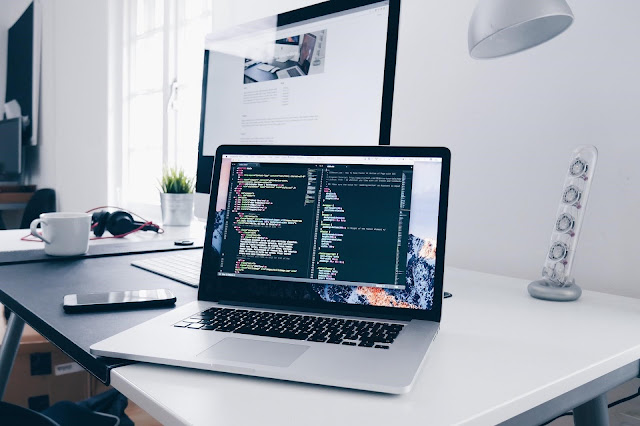 A picture of a laptop with a coding program on the screen