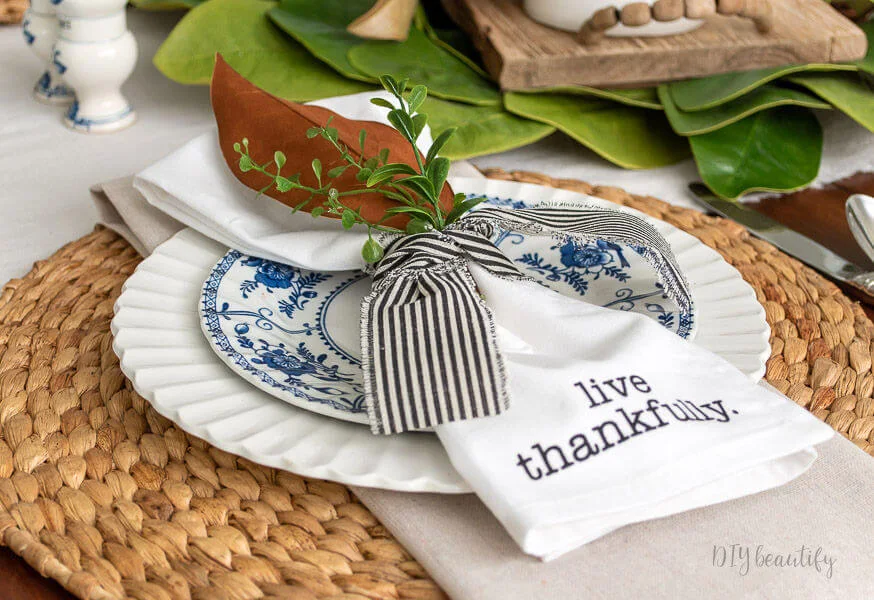 magnolia leaf and greenery, black striped ribbon, blue and white dishes