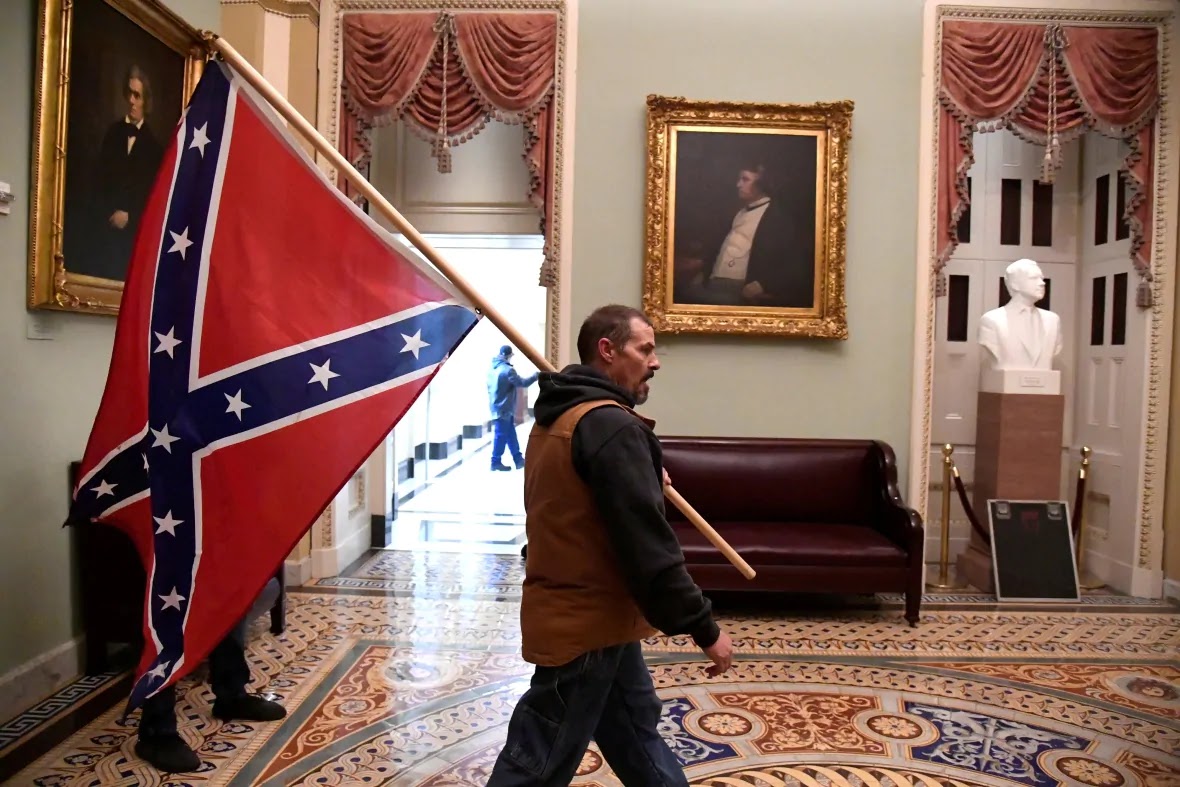 Hombre se pasea con bandera en el capitolio