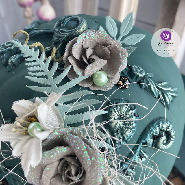 Dark green altered pumpkin with a dark academia aesthetic using moulds, flowers, pearls and gems from Prima Marketing Inc. (Lost in Wonderland, Twilight and The Plant Department Collections); Frank Garcia Memory Hardware; and Finnabair moulds, paint and wax.