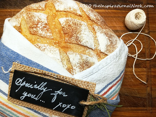 A gift of bread, wrapped in a dish towel, cloth, French boule bread, Boule bread, Country Boule, cross hatch lines, bread scoring technique, cross hatch slash, French Country Style Bread, Cross hatched bread scoring