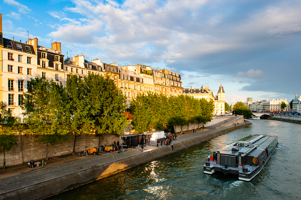 a photo of a film crew working on the banks of the seine river paris france